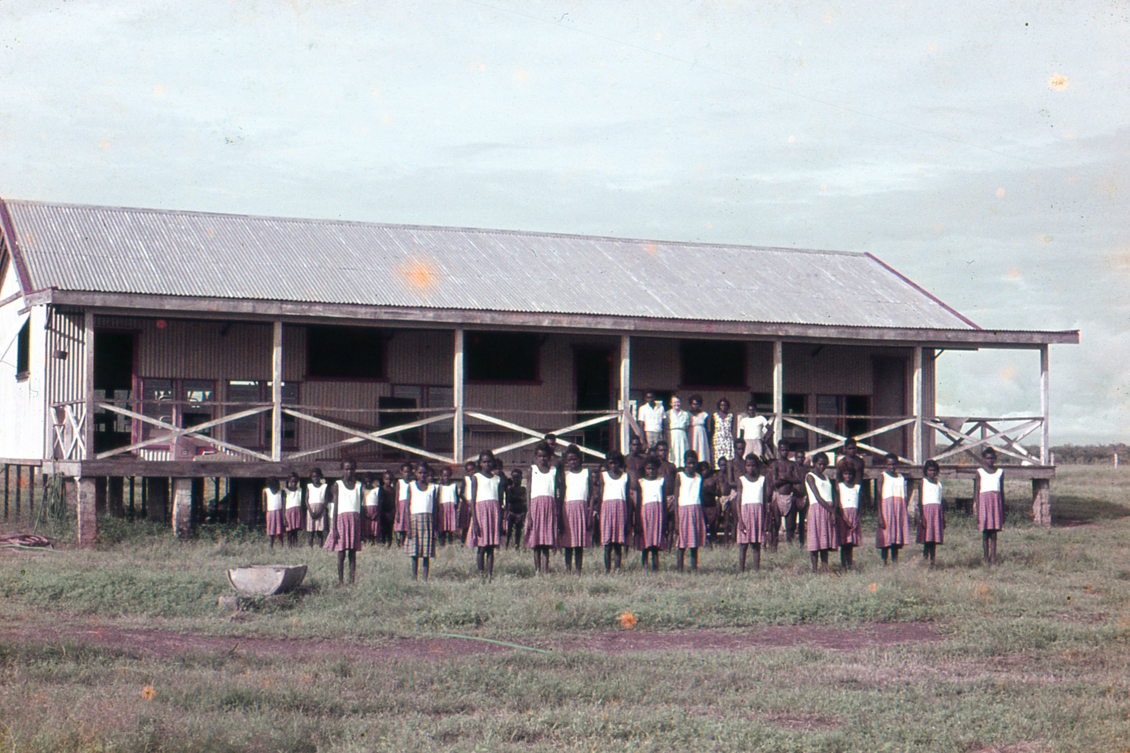 Children lining up in front of a school