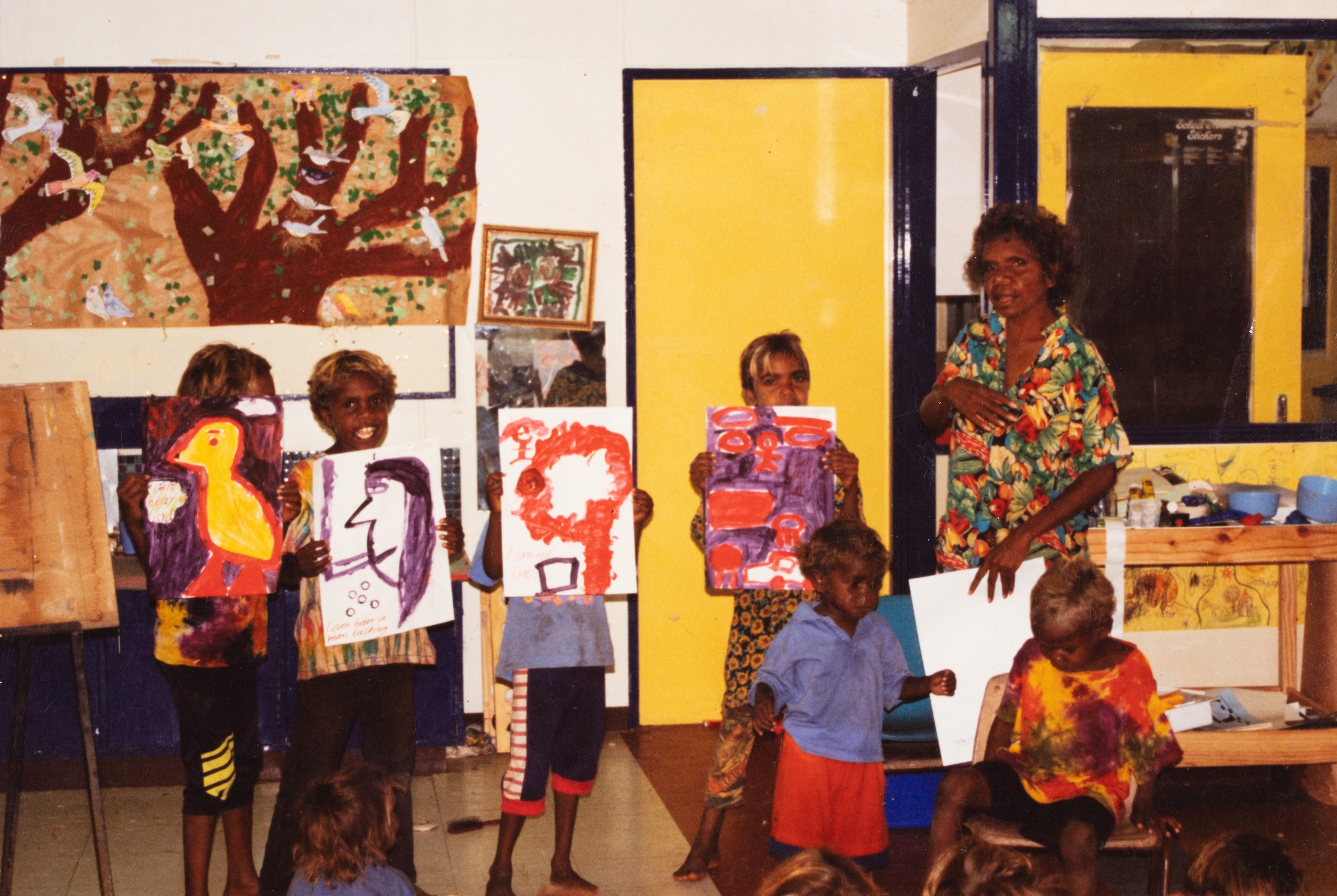 eacher Tarna Andrews and students displaying their art work